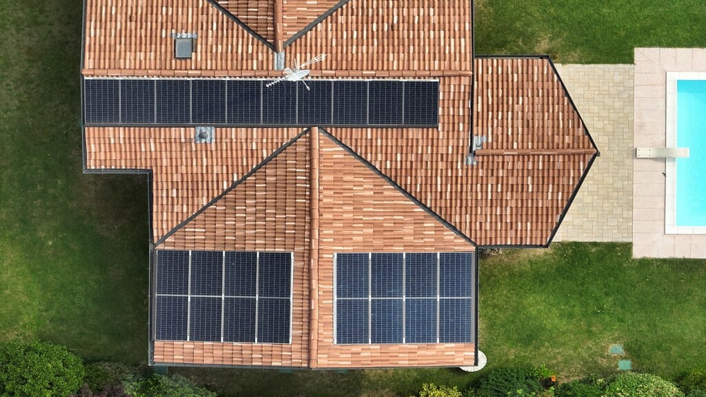 Impianto fotovoltaico su casa con giardino e piscina
